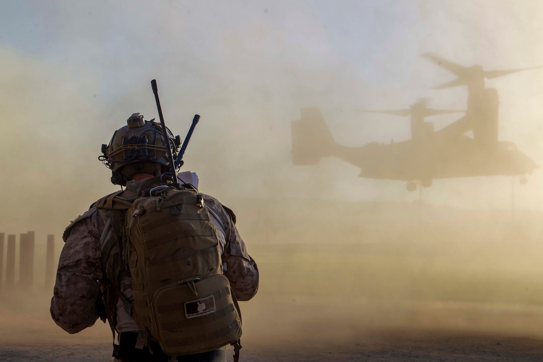 U.S. Marine Corps Gunnery Sgt. Thomas Dye, perspective Weapons and Tactics Instructor (WTI)  with Force Reconnaissance Company, 3rd Reconnaissance Battalion, watches an MV-22B Osprey aircraft land during a noncombatant evacuation operation (NEO) exercise as part of Weapons and Tactics Instructor course 1-23 at Marine Corps Air Ground Combat Center, Twentynine Palms, California, Oct. 27, 2022. The NEO simulated real-life scenarios for Marines to practice the evacuation of noncombatants from potentially dangerous areas. (U.S. Marine Corps photo by Lance Cpl. Jacquilyn Davis)