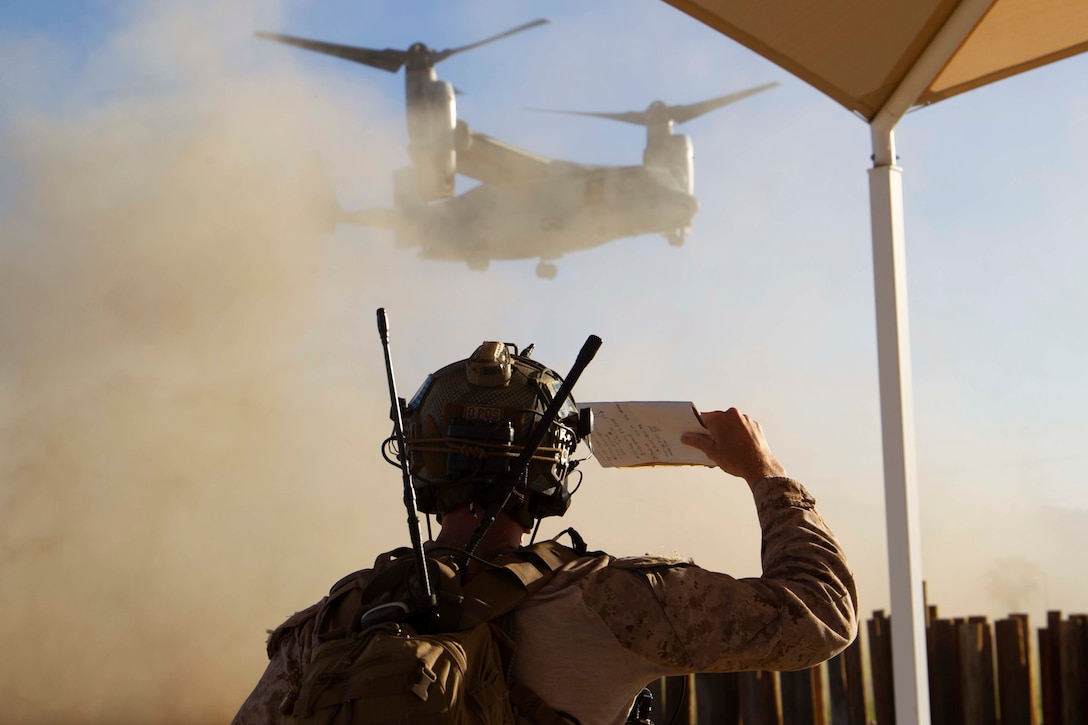 U.S. Marine Corps Gunnery Sgt. Thomas Dye, a prospective Weapons and Tactics Instructor (WTI) with Force Reconnaissance Company, 3rd Reconnaissance Battalion, observes an MV-22B Osprey aircraft during a noncombatant evacuation operation (NEO) exercise as part of  WTI 1-23 course at Marine Corps Air Ground Combat Center, Twentynine Palms, California, Oct. 27, 2022. The NEO simulated real-life scenarios for Marines to practice the evacuation of noncombatants from potentially dangerous areas. (U.S. Marine Corps photo by Lance Cpl. Jacquilyn Davis)