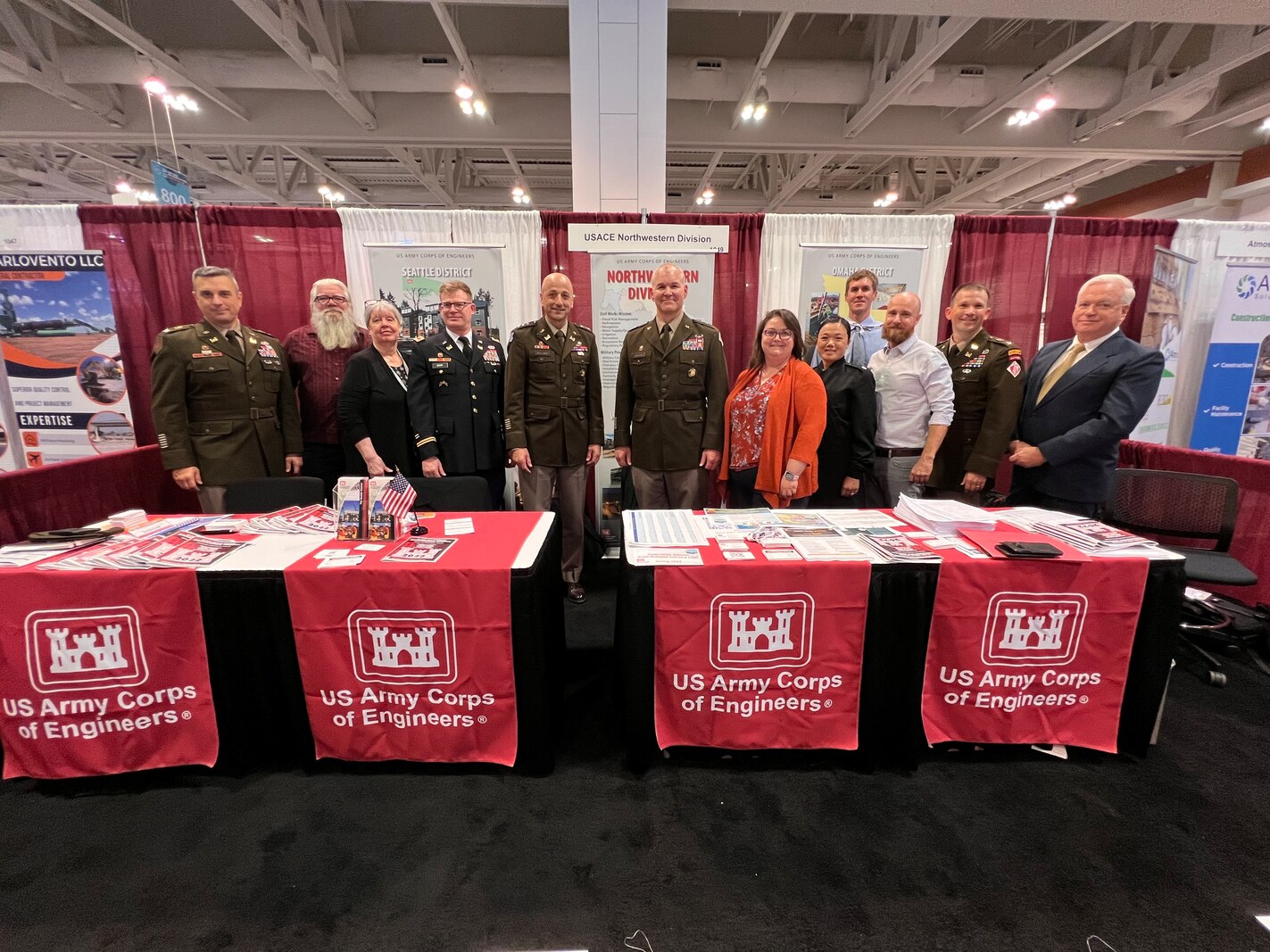 Photo of a group of people standing behind exhibit booth tables.