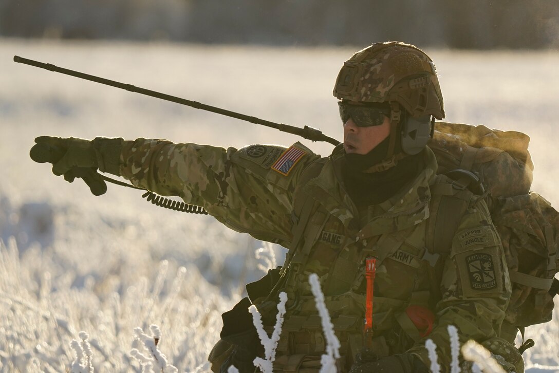 University of Alaska Army ROTC Cadet Ralph Sumagang gives movement commands to his squad members during an air assault training event at Joint Base Elmendorf-Richardson, Alaska, Dec. 2. The Seawolf ROTC Detachment maneuvered across more than one mile of frozen terrain to assault opposition forces and secure its objective. The Alaska Army National Guard’s General Support Aviation Battalion routinely trains with all branches of the military as well as civilian agencies to increase its operational interoperability and to be ready for a wide range of federal and state missions. (Alaska National Guard photo by Dana Rosso)