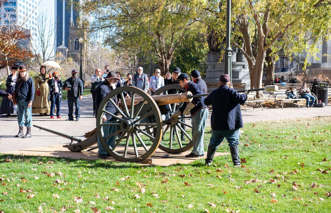 Civil War reenactors prepare to fire a brass cannon in front of the Ohio Statehouse.