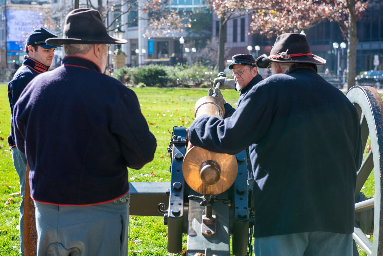 Civil War reenactors prepare to fire a brass cannon in front of the Ohio Statehouse.