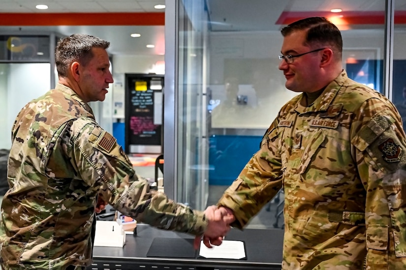 Chief Master Sgt. David Kolcun, 305th Air Mobility Wing command chief, coins Tech. Sgt. Curtis Armstrong, 305th Air Mobility Wing innovation lab subject matter expert, at Joint Base McGuire-Dix-Lakehurst, N.J. on Dec. 5, 2022. The 305th Innovation Lab was acknowledged for its numerous contributions to the Joint Base and Air Mobility Command.