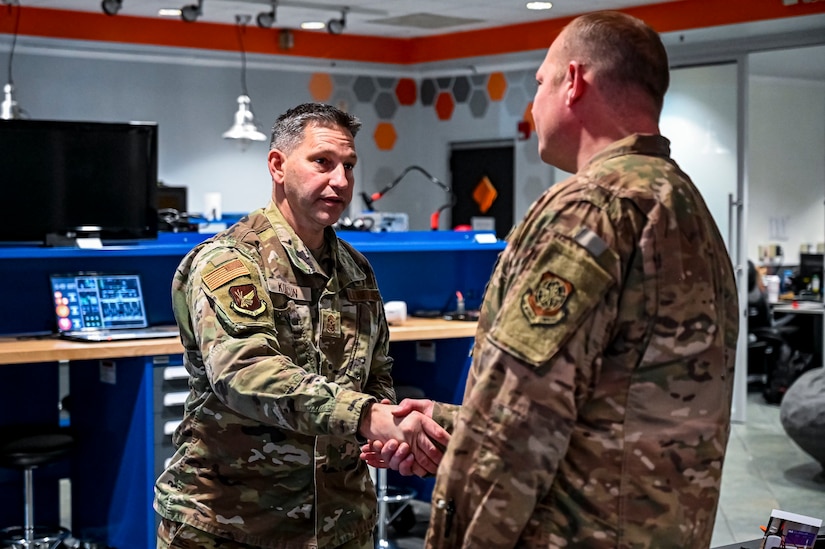 Chief Master Sgt. David Kolcun, 305th Air Mobility Wing command chief, coins Master Sgt. Steven Hoare, 305th Air Mobility Wing innovation lab superintendent, at Joint Base McGuire-Dix-Lakehurst, N.J. on Dec. 5, 2022. The 305th Innovation Lab was acknowledged for its numerous contributions to the Joint Base and Air Mobility Command.