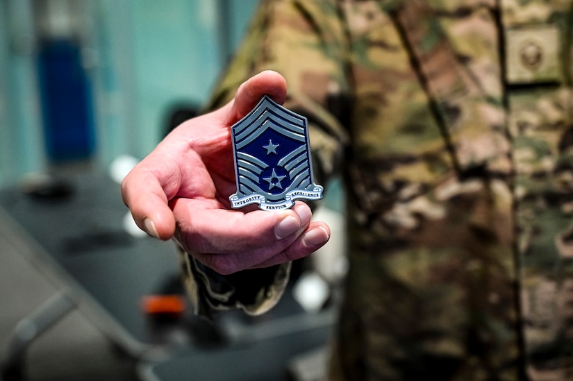 U.S. Air Force Master Sgt. Steven Hoare, 305th Air Mobility Wing innovation lab superintendent, displays a coin at Joint Base McGuire-Dix-Lakehurst, N.J. on Dec. 5, 2022. The 305th Innovation Lab was acknowledged for its numerous contributions to the Joint Base and Air Mobility Command.