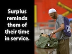 A man looks through a bag of surplus items.