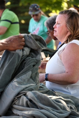 A woman stands at a surplus property table.