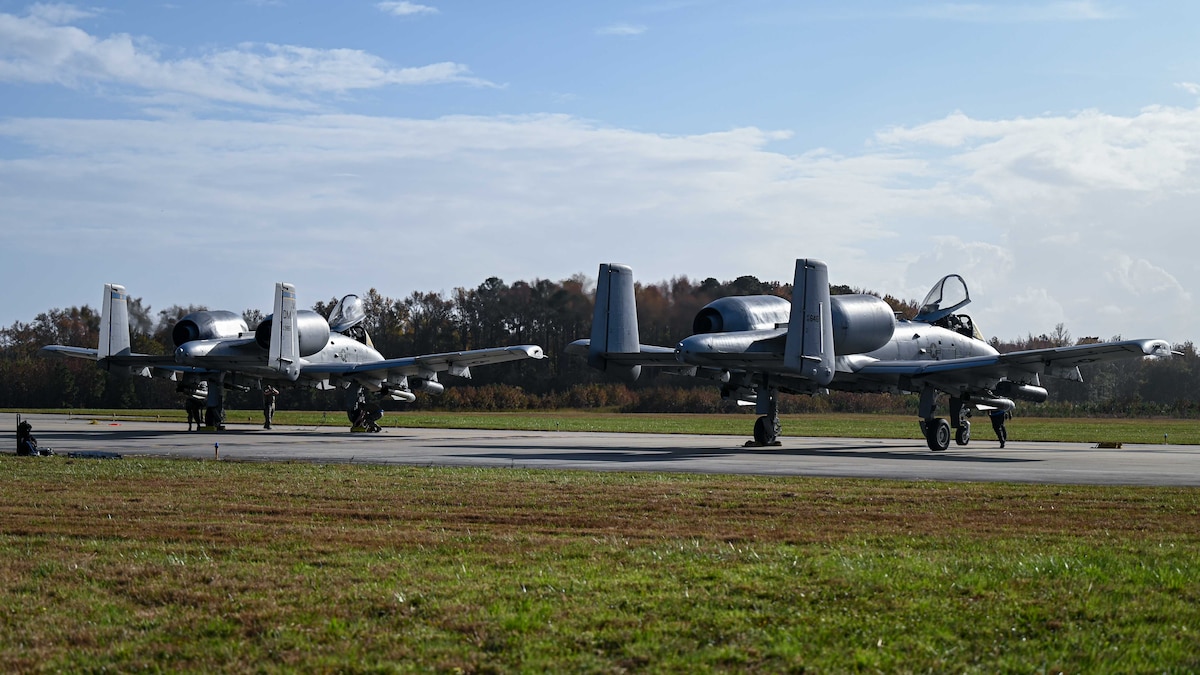A photo of two military aircraft sitting on a flightline.