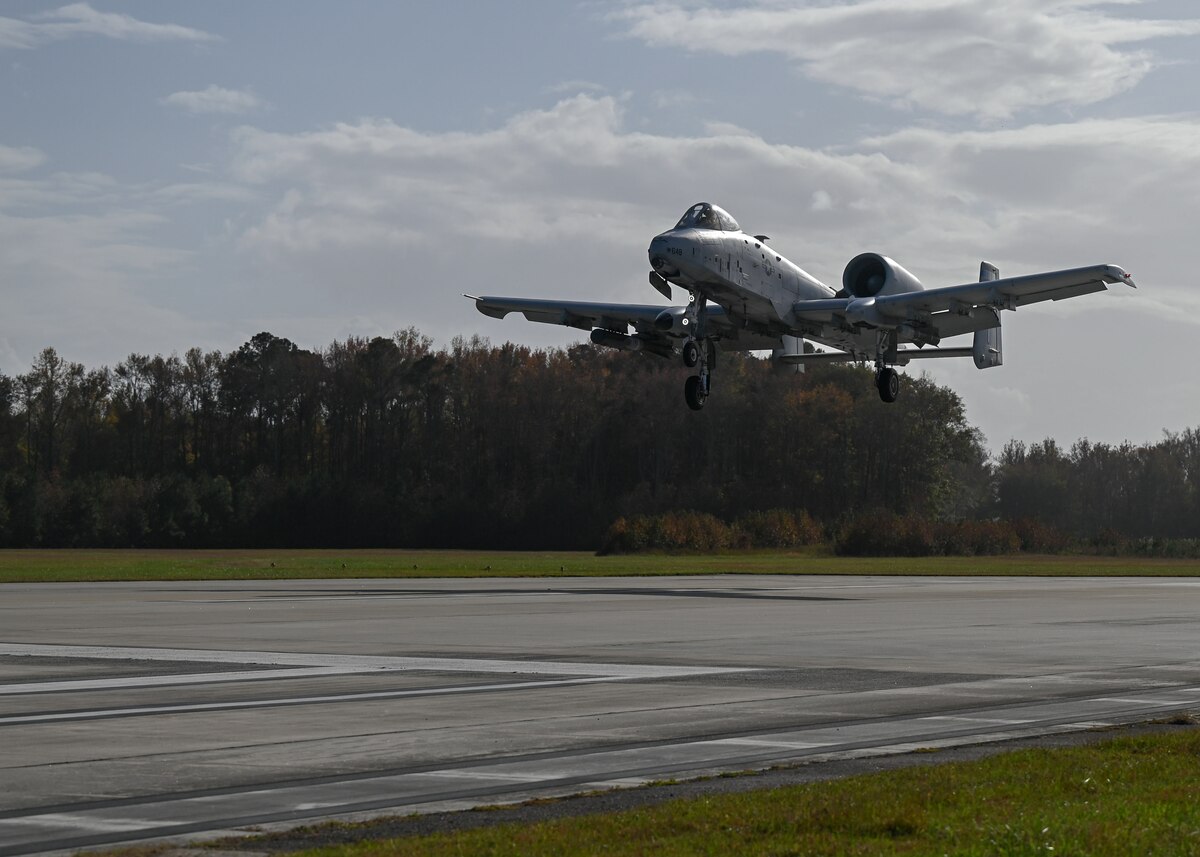 A photo of a military aircraft landing on a runway.
