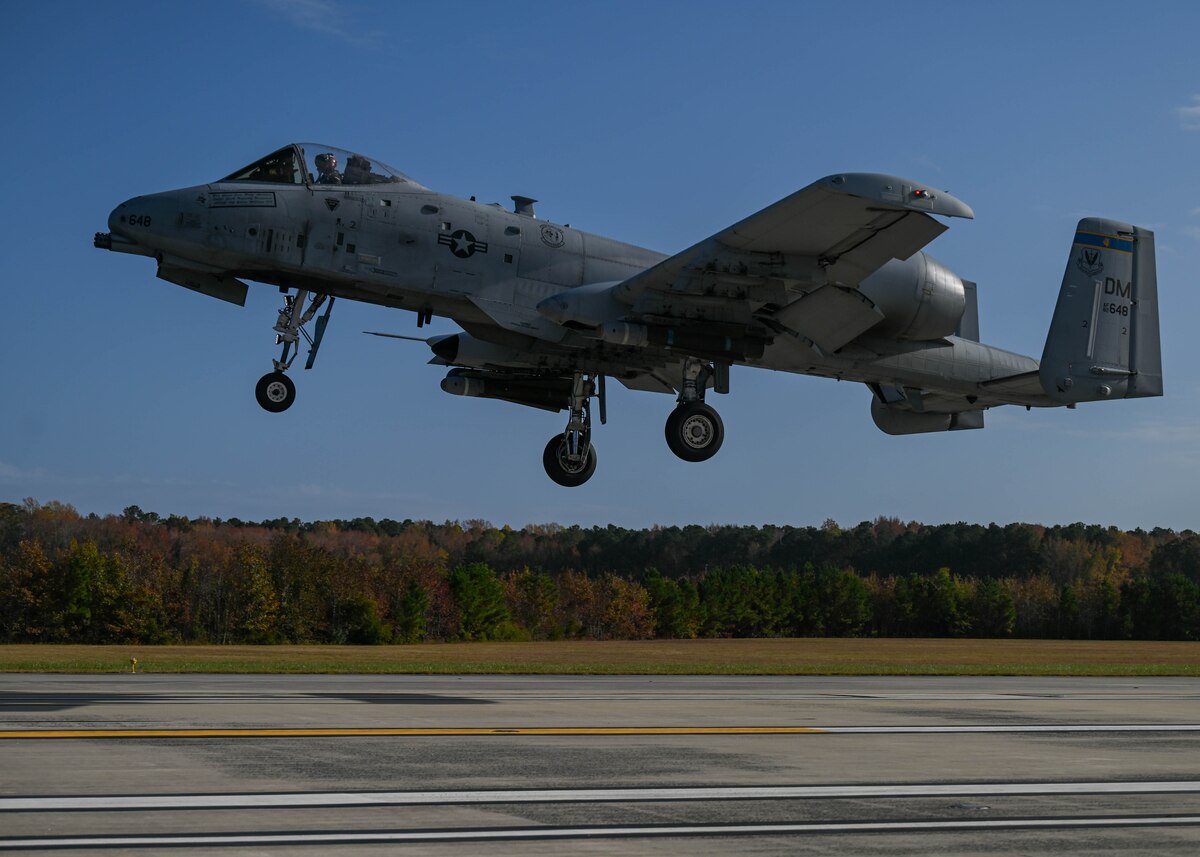 A photo of a military aircraft landing on a runway.