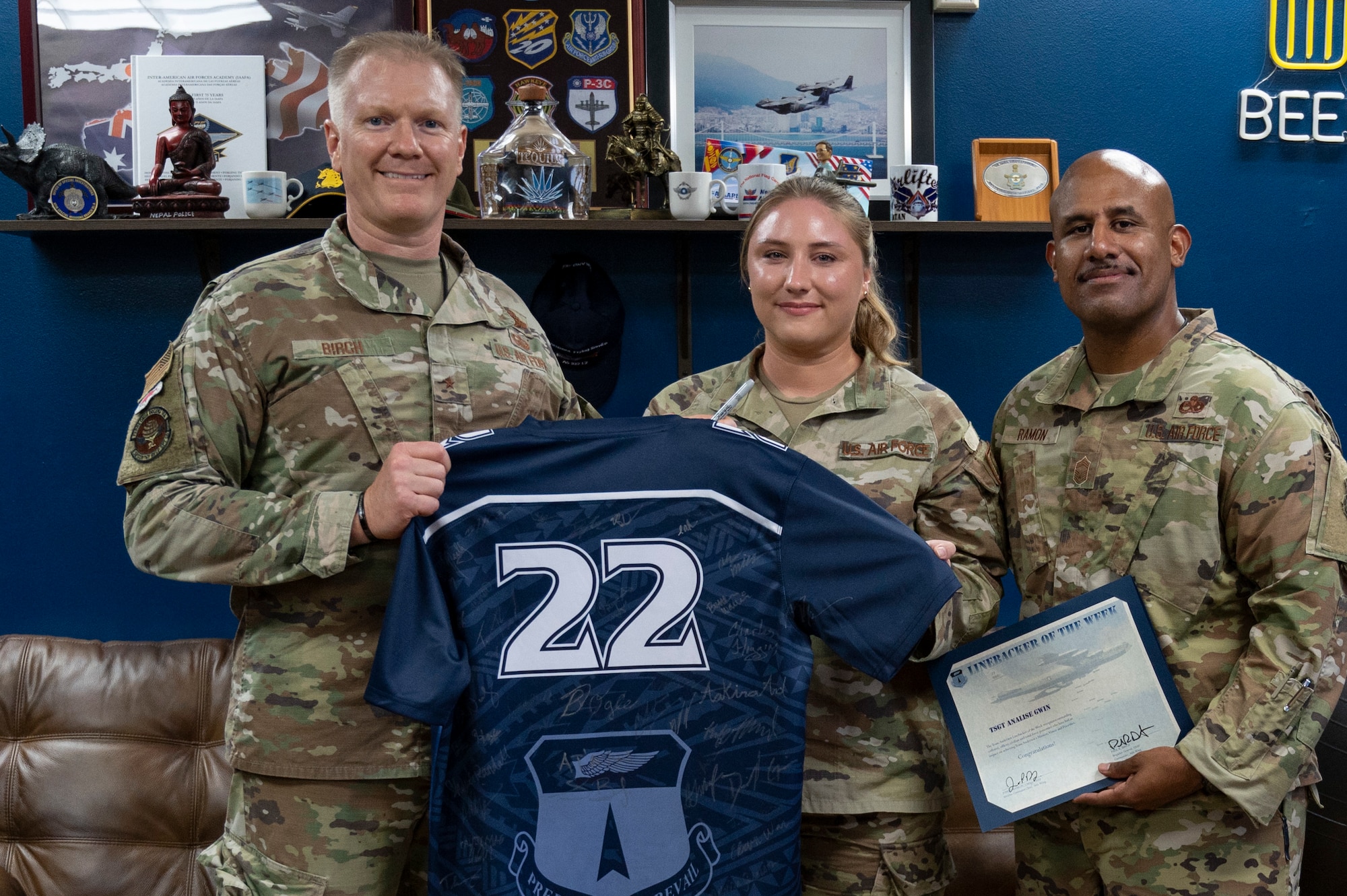 U.S. Air Force Tech. Sgt. Analise Gwin, the noncommissioned officer in charge of the commander’s support staff assigned to the 36th Contingency Response Support Squadron, receives the Linebacker of the Week Award from U.S. Air Force Brig. Gen Paul Birch, the 36th Wing commander, and U.S. Air Force Chief Master Sgt. Jose Ramon, the senior enlisted leader of the 36th Maintenance Group, at Andersen Air Force Base, Guam, Dec. 2, 2022. The Team Andersen Linebacker of the Week recognizes outstanding enlisted, officer, civilian and total force personnel who have had an impact on achieving Team Andersen’s mission, vision and priorities. (U.S. Air Force photo by Airman 1st Emily Saxton)