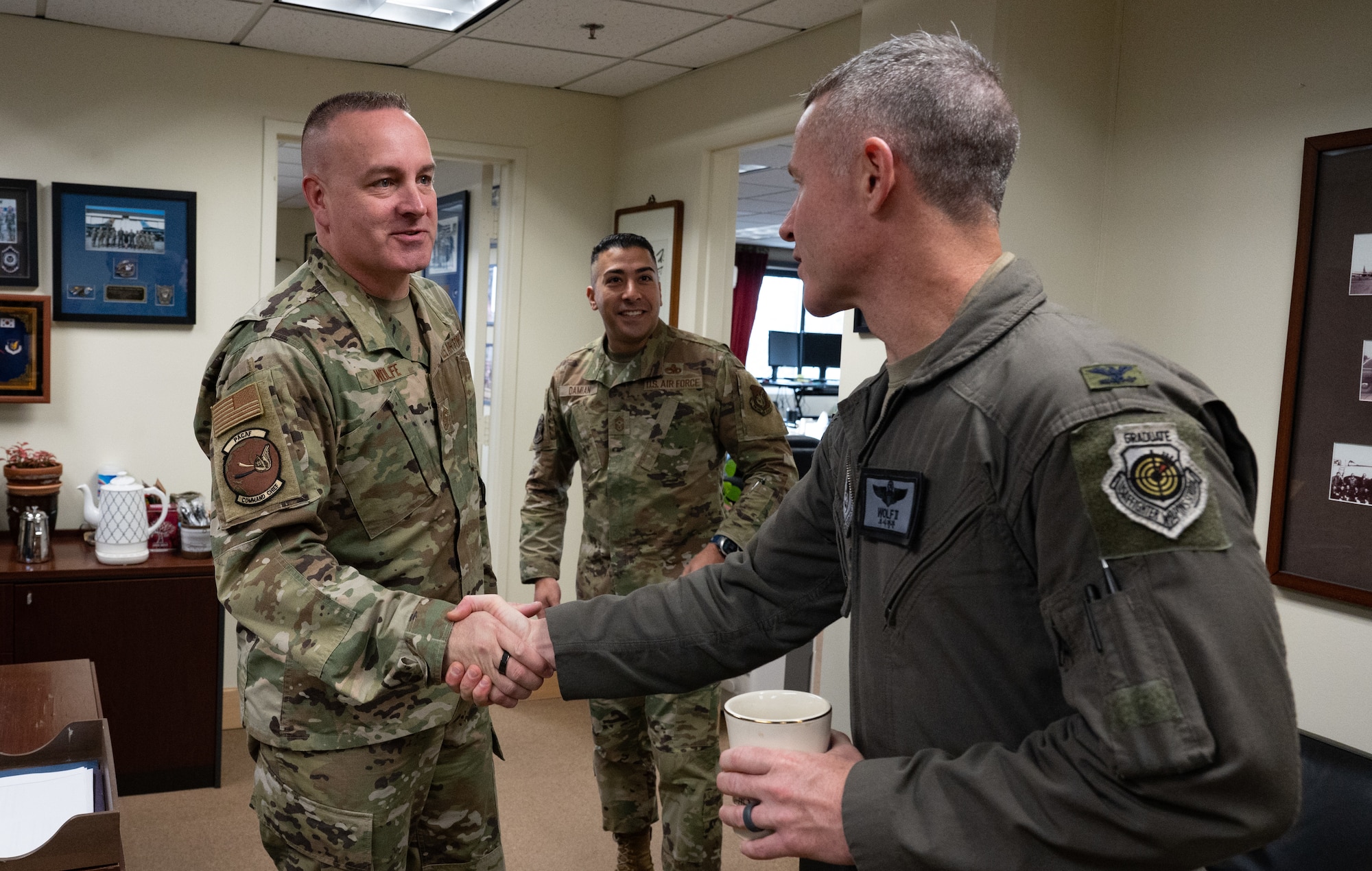Chief Master Sgt. David R. Wolfe (left), Pacific Air Forces Command chief master sergeant, shakes hands with Col. John Caldwell, 8th Fighter Wing vice commander, at Kunsan Air Base, Republic of Korea, Dec. 5, 2022. Wolfe received a familiarization brief from Caldwell and Chief Master Sgt. Carlos Damian, 8th Fighter Wing command chief, to learn of Kunsan’s strategic mission and how the Wolf Pack plays a role in supporting an open and free Indo-Pacific theater. (U.S. Air Force photo by Staff Sgt. Sadie Colbert)