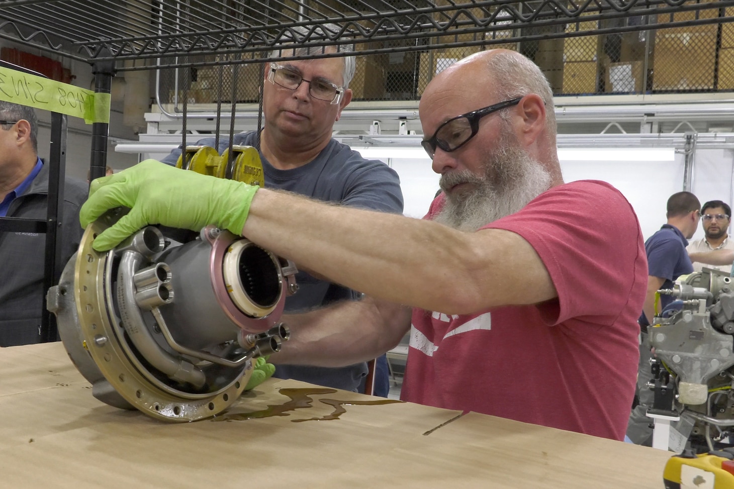 Mechanics inspect T408 engine part