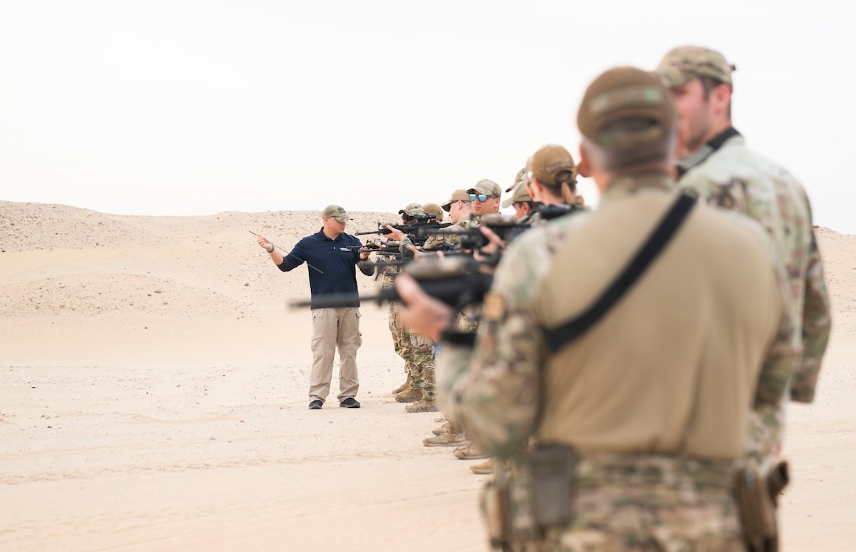 U.S. Air Force Airmen from the 386th Expeditionary Security Forces Squadron line up to have their weapons inspected during a range day at Camp Buehring, Kuwait, Nov. 30, 2022. Members went over various techniques and had the chance to practice fundamentals as well as advanced  weapon transitions. (U.S. Air Force photo by Staff Sgt. Ashley N. Mikaio)