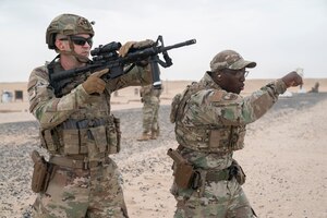 From left, U.S. Air Force Staff Sgt. William Harvey, 386th Expeditionary Security Forces Squadron base defense operations center controller, receives instruction from Tech. Sgt. Vincent Scott, 386th Expeditionary Security Forces Squadron instructor, on transitioning from M4 to M9 during a range day at Camp Buehring, Kuwait, Nov. 30, 2022. Instructors stressed the importance of transition drills and getting back in the fight if a weapon system goes down. (U.S. Air Force photo by Staff Sgt. Ashley N. Mikaio)