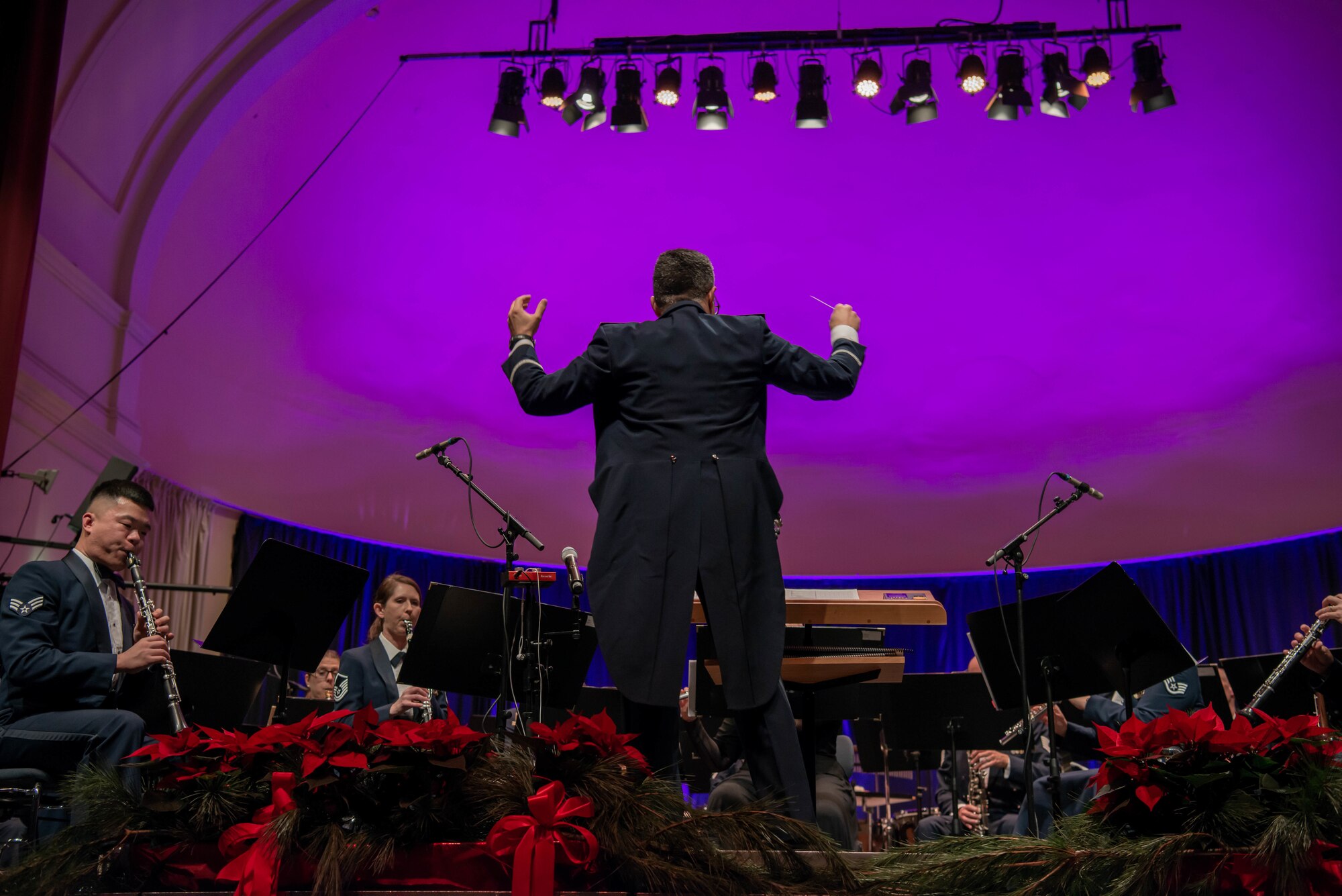 Conductor conducts a band during holiday concert