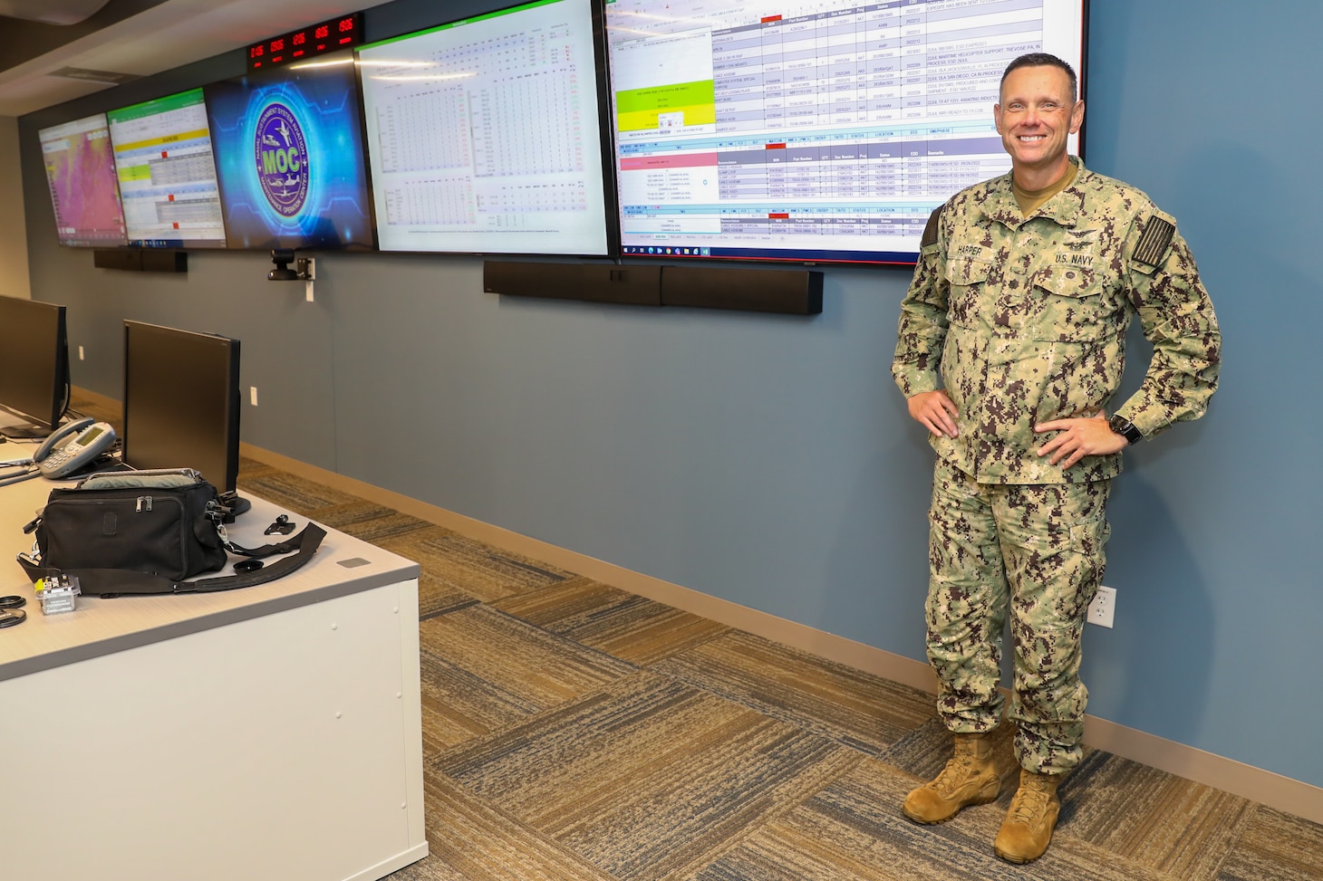 Cmdr. Ronnie Harper, Maintenance Operation Center (MOC) Aircraft on Ground (AOG) director, poses for a photo in the MOC control room, July 26.