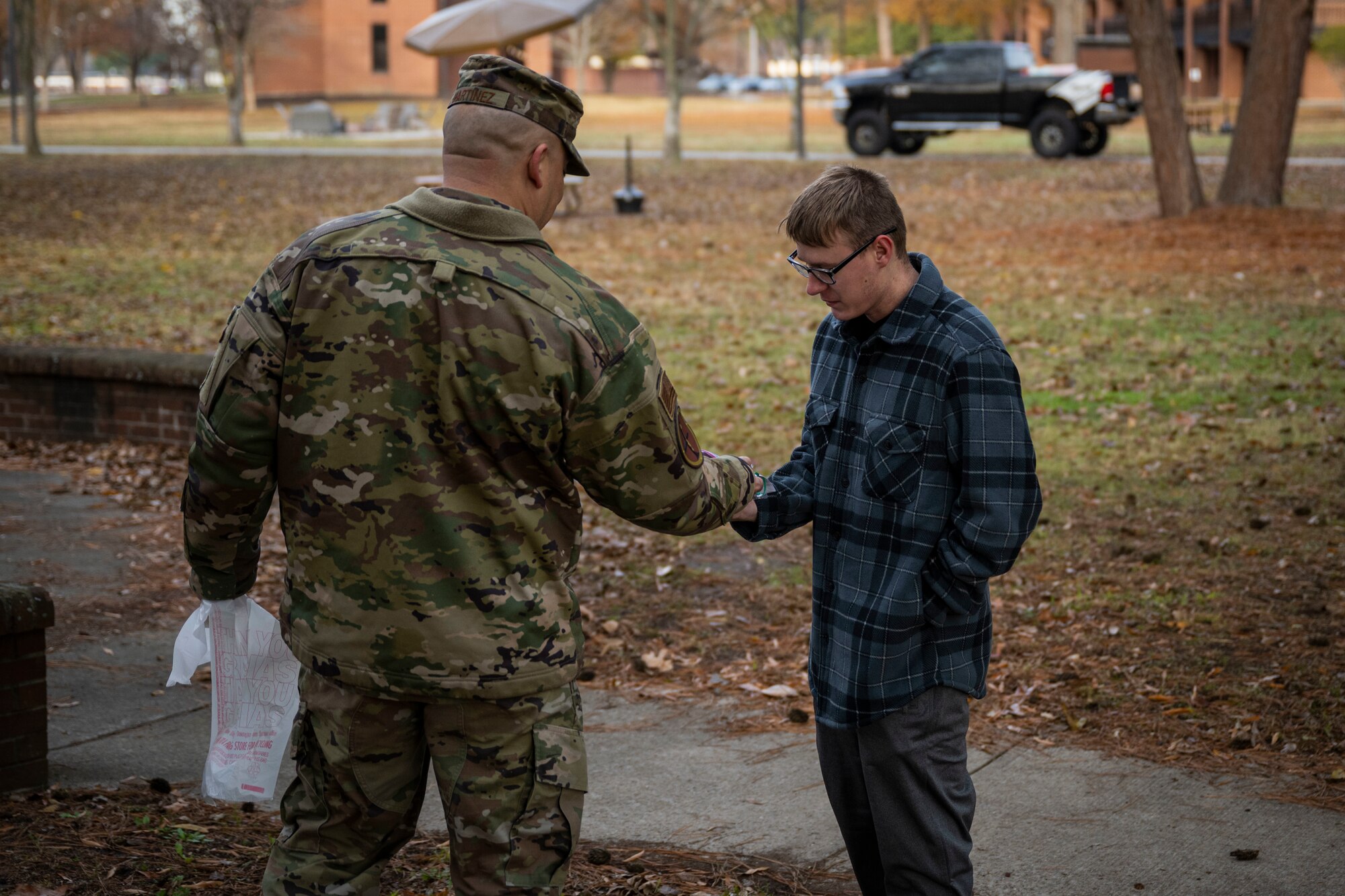 Chief Master Sgt. Peter Martinez, 4th Fighter Wing command chief, shakes hands with an Airman assigned to the 4th FW while handing out cookies as part of the annual cookie drive at Seymour Johnson Air Force Base, North Carolina, Dec. 5, 2022. More than 6,000 cookies donated for 600 dorm Airmen.