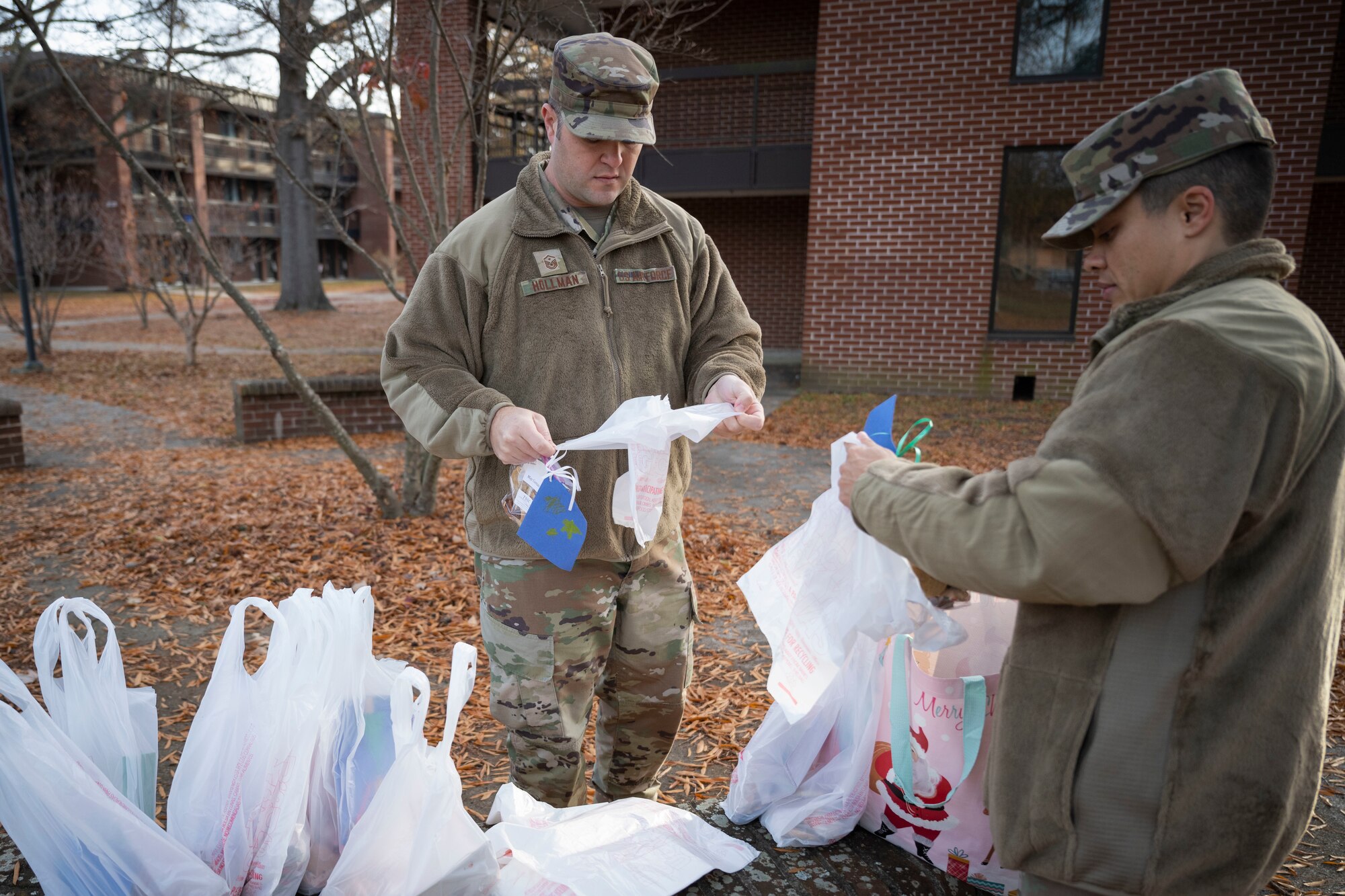 Master Sgt. Brandon Hollman, left, 4th Comptroller Squadron and 4th Force Support Squadron first sergeant, and Master Sgt. Kayleigh McAviney, 335th Fighter Generation Squadron first sergeant, prepare cookie bags for dorm Airmen as part of the annual cookie drive at Seymour Johnson Air Force Base, North Carolina, Dec. 5, 2022. The cookies were distributed to 600 Airmen.