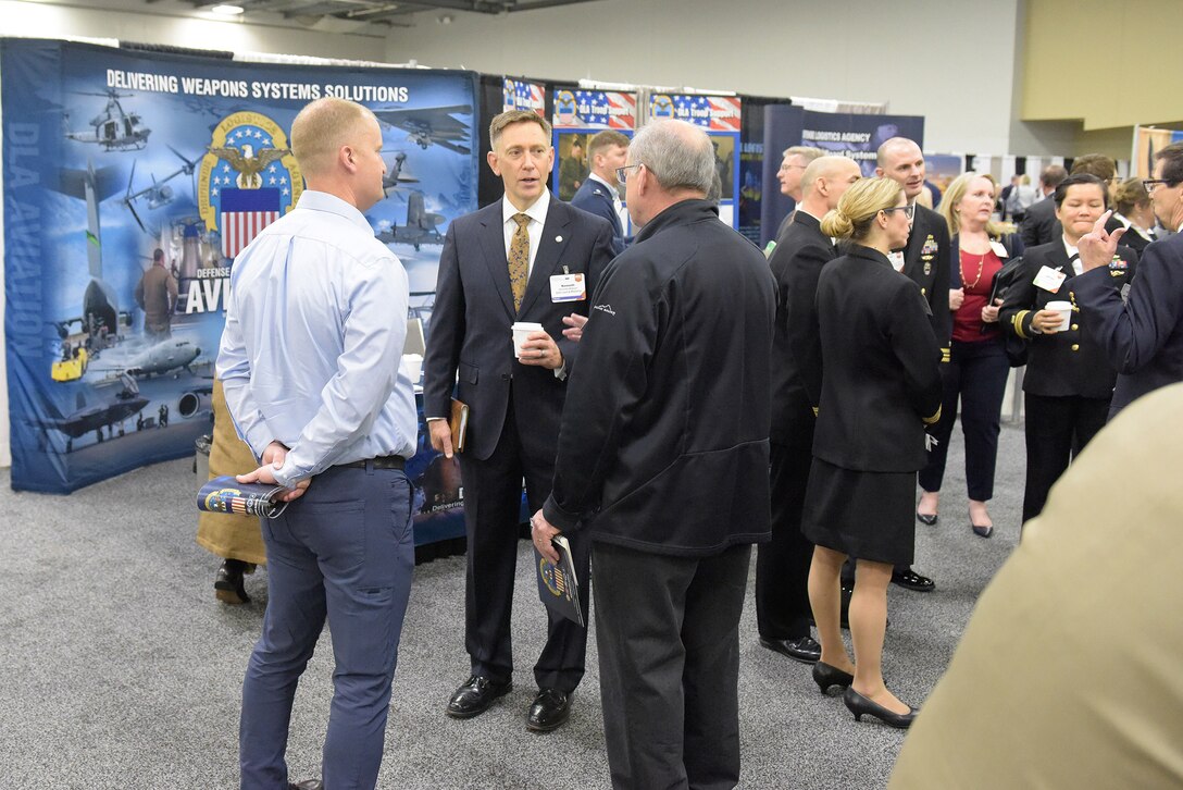 A group of men and women stand in front of exhibit displays