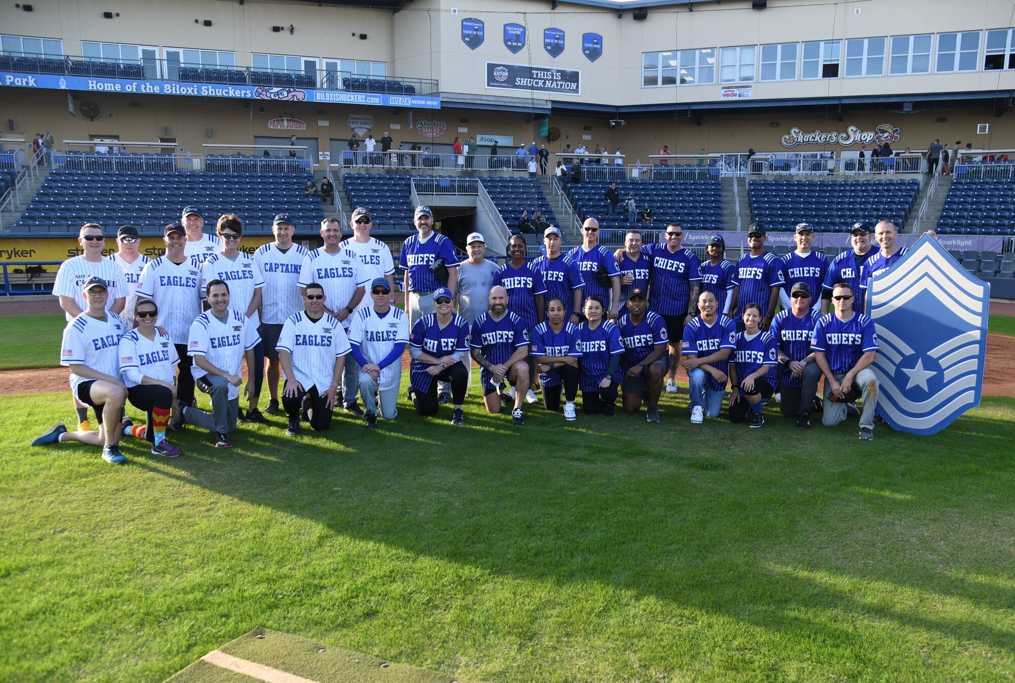 Team members pose for a group photo during the 2nd Annual Chiefs vs. Eagles softball game at MGM Park in Biloxi, Mississippi, Dec. 5, 2022.