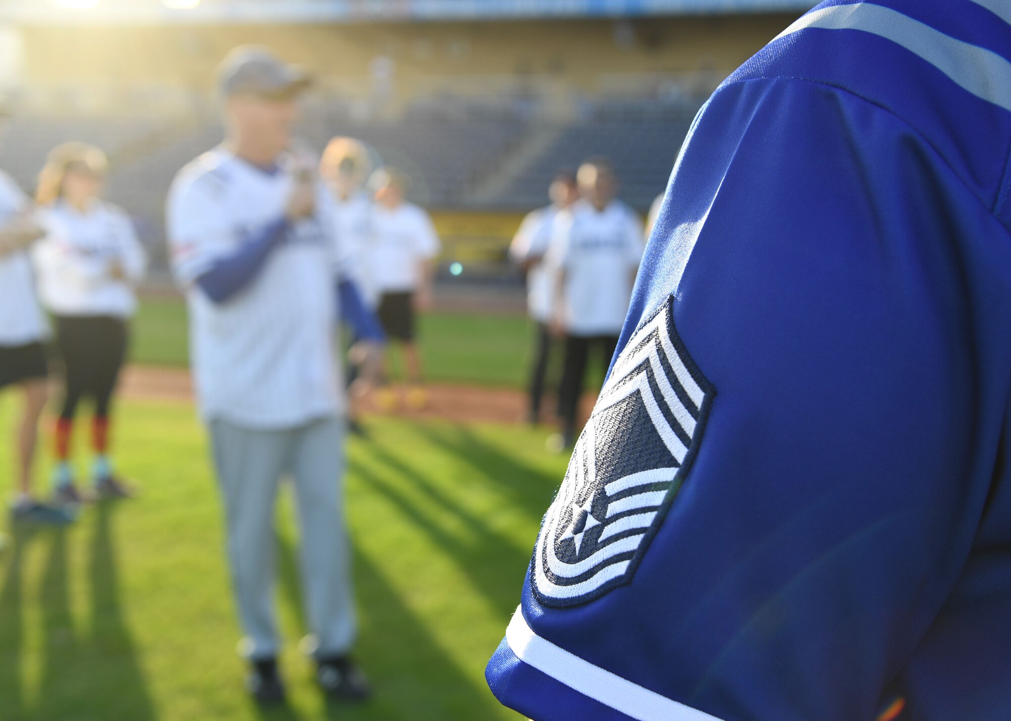 U.S. Air Force Chief Master Sgt. Sarah Esparza, 81st Training Wing command chief, stands by as Col. William Hunter, 81st TRW commander, delivers closing remarks during the 2nd Annual Chiefs vs. Eagles softball game at MGM Park in Biloxi, Mississippi, Dec. 5, 2022.