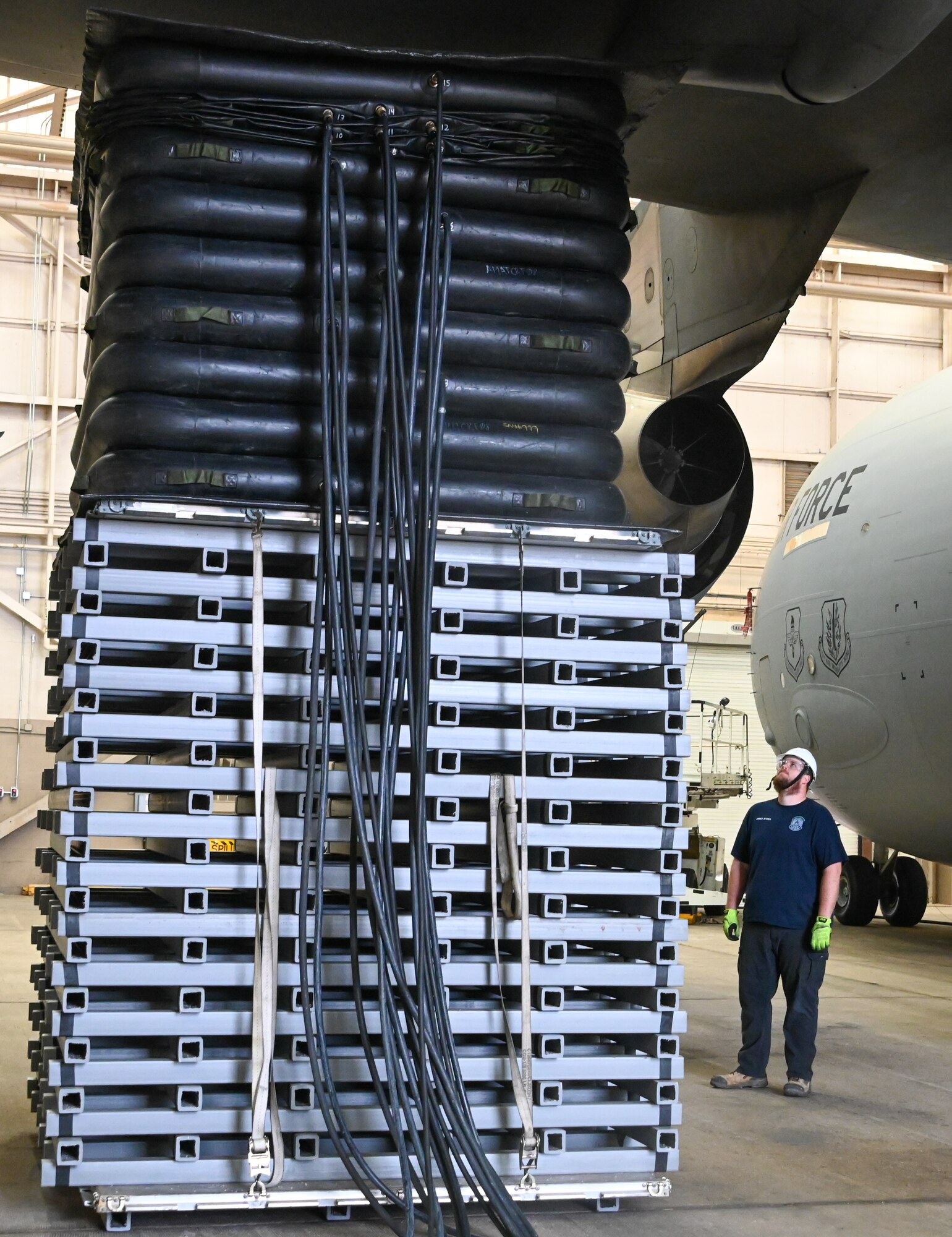 James Atwell, 97th Maintenance Squadron aircraft mechanic, looks up as air is pumped into the inflatable balloons on top of new cribbing used for the Crashed Disabled Damaged Aircraft Recovery Program at Altus Air Force Base, Oklahoma, Dec. 7, 2022. The new cribbing makes lifting heavier aircraft parts easier and safer while also saving money and time. (U.S. Air Force photo by Senior Airman Kayla Christenson)