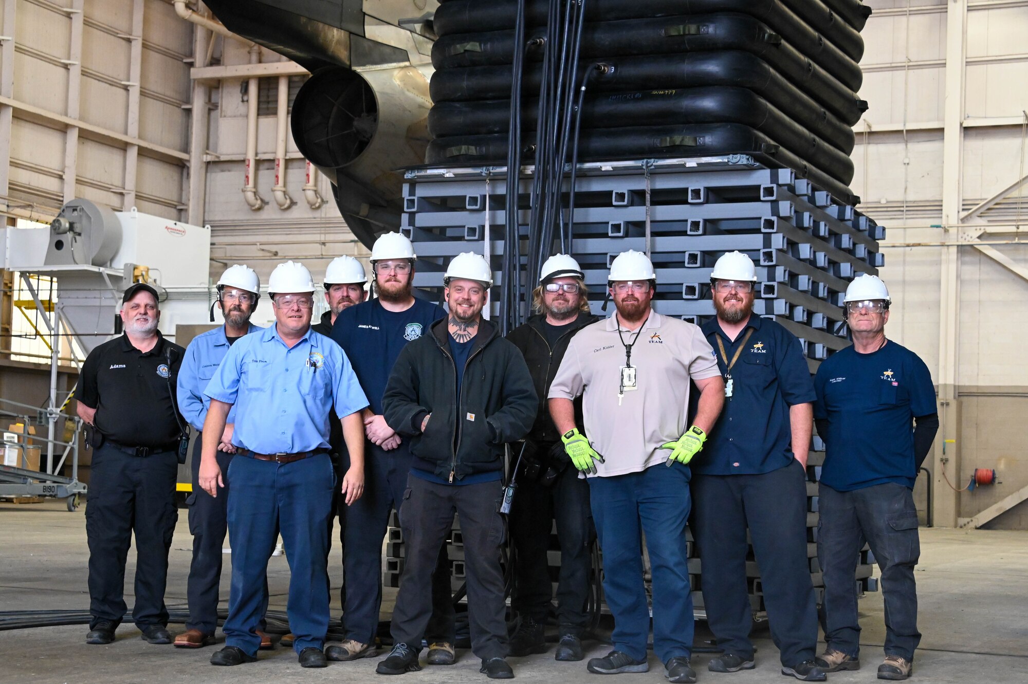 Members from the 97th Maintenance Squadron and Crashed Disabled Damaged Aircraft Recovery Program pose for a group photo in front of the new cribbing recently bought for improved recovery time of crashed or disabled aircraft at Altus Air Force Base, Oklahoma, Dec. 7, 2022. The previous cribbing was made of wood, making the equipment much heavier - 86 pounds per piece - compared to the plastic cribbing which is 22 pounds per piece. (U.S. Air Force photo by Senior Airman Kayla Christenson)