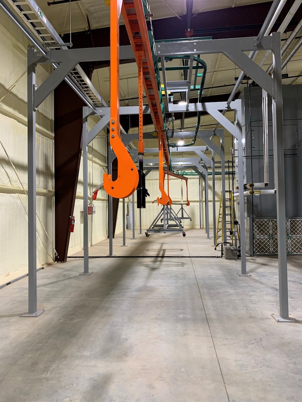 The overhead conveyor system used for the new Robotic Spray Facility purchased as Government Furnished Equipment and used in the production of CH-53K fuel cells.