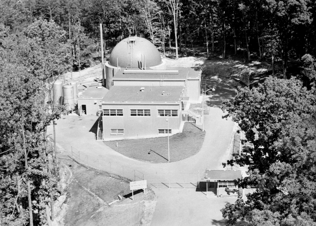 Black and white photo of SM-1 building surrounded by trees at Fort Belvoir.