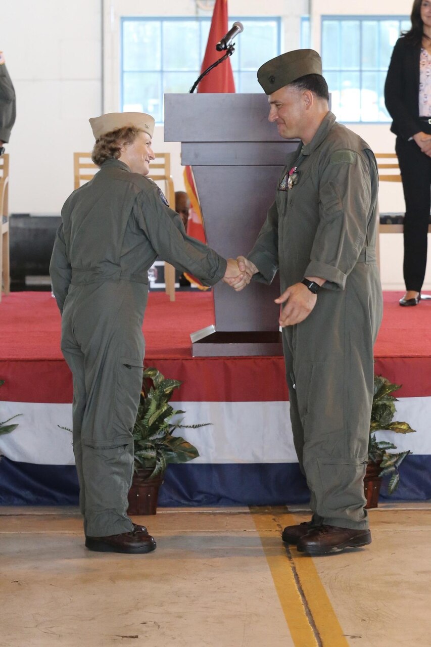 Capt. Elizabeth Somerville shakes hands with Col. Richard Marigliano after taking command of Naval Test Wing Atlantic during a ceremony at Naval Air Station Patuxent River, Maryland, Aug. 11. Somerville is the developmental test wing’s first woman commodore. During the ceremony, Marigliano retired from the U.S. Marine Corps after 27 years of service.