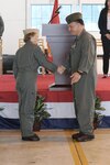 Capt. Elizabeth Somerville shakes hands with Col. Richard Marigliano after taking command of Naval Test Wing Atlantic during a ceremony at Naval Air Station Patuxent River, Maryland, Aug. 11. Somerville is the developmental test wing’s first woman commodore. During the ceremony, Marigliano retired from the U.S. Marine Corps after 27 years of service.