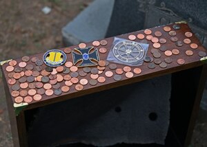 Coins rest on a piece of the USS Arizona after the Pearl Harbor Remembrance Day ceremony at Fairmount Cemetery, San Angelo, Texas, Dec. 7, 2022. U.S. Navy Seaman 1st Class Walton O. Irwin was a casualty of Pearl Harbor, and a piece of the USS Arizona was brought to the grave of his parents as a way for him to be with them one last time. (U.S. Air Force photo by Senior Airman Ethan Sherwood)