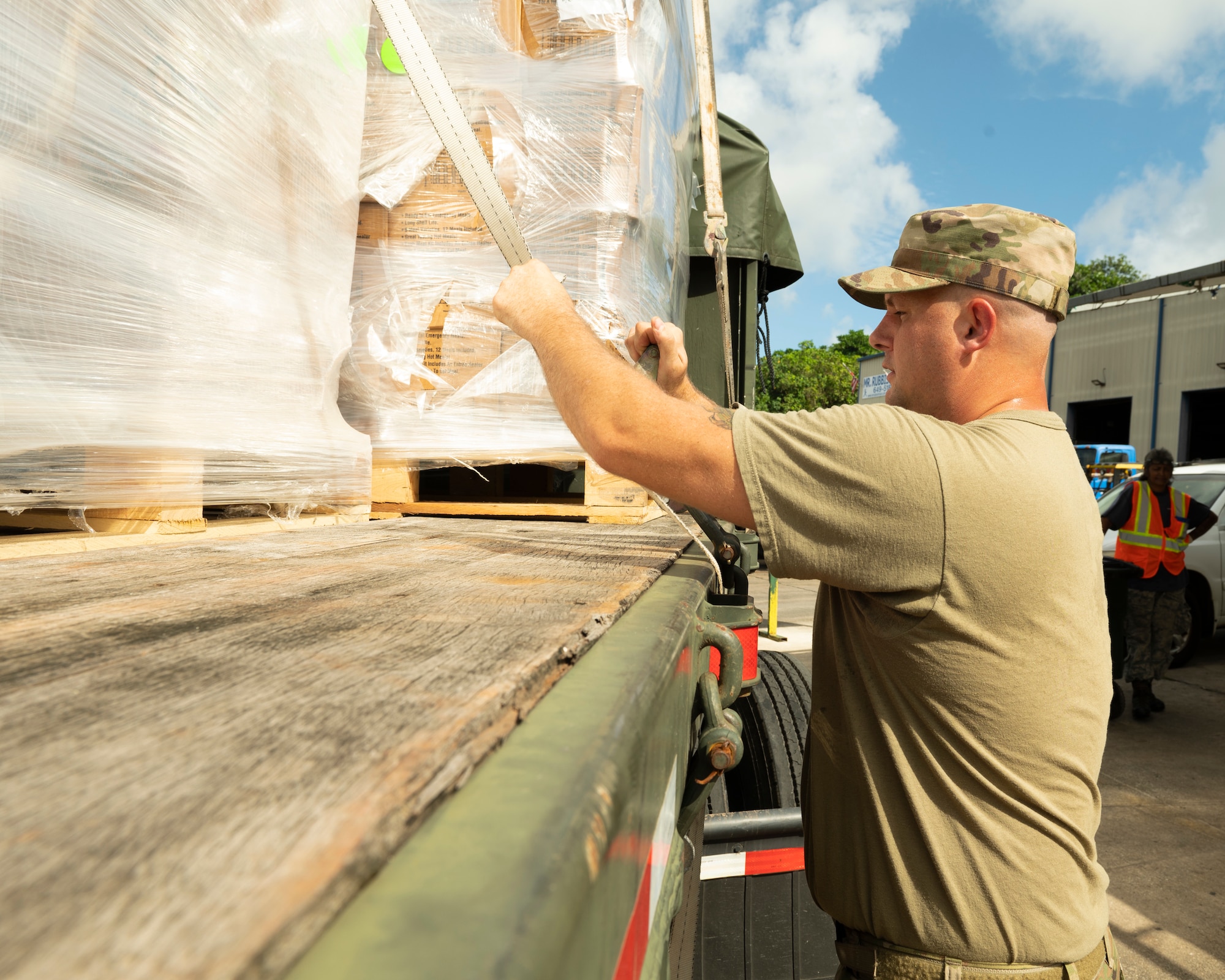 U.S. Air Force Tech. Sgt. Gregory Allen, 36th Logistics Readiness Squadron ground transportation noncommissioned officer, tightens a strap to hold down pallets of ready-to-eat meals in Dededo, Guam, Nov. 30, 2022. Members of the ground transportation team moved about 50,000 pounds of cargo in support of the 71st Operation Christmas Drop. (U.S. Air Force photo by Airman Spencer Perkins)