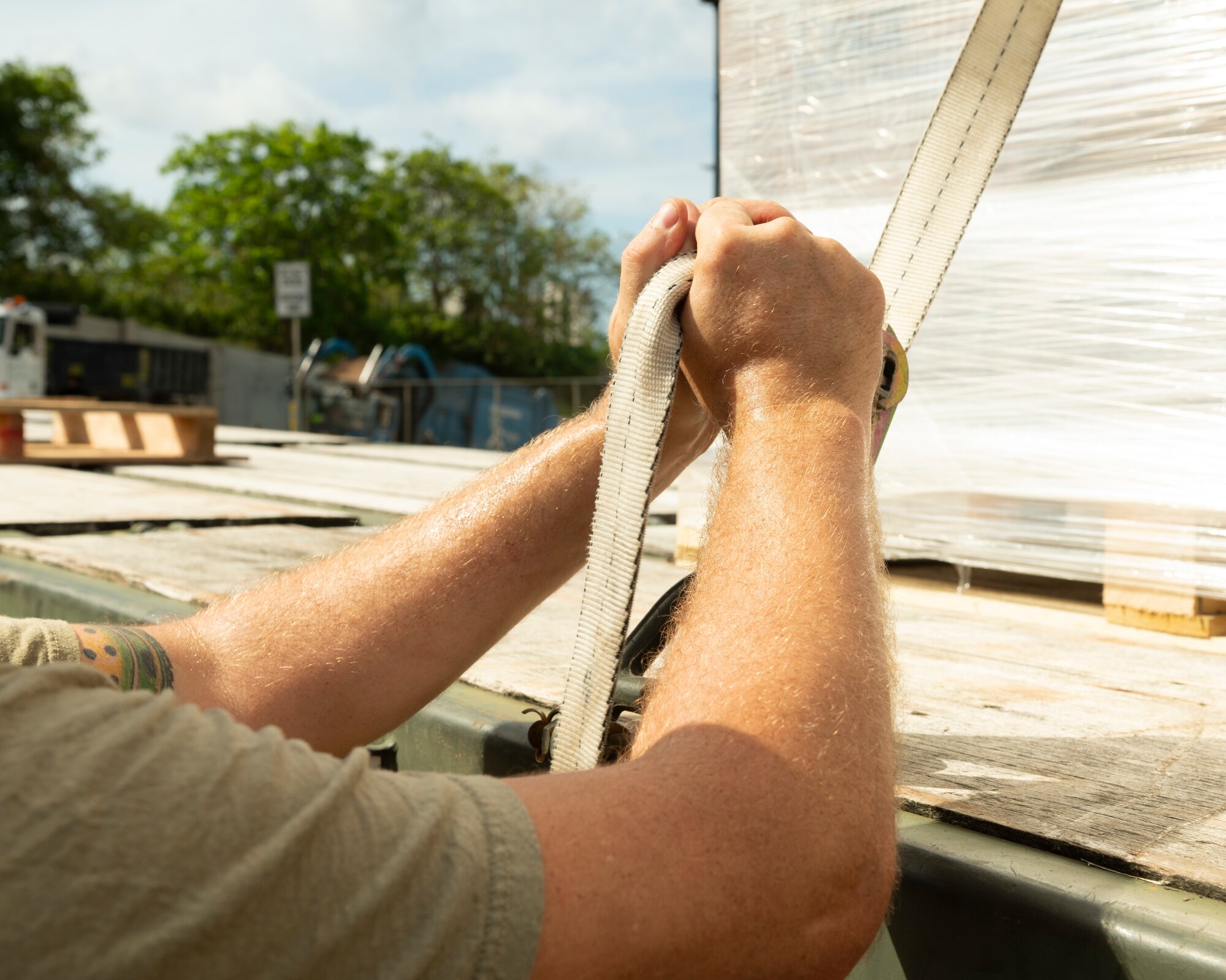 U.S. Air Force Tech. Sgt. Gregory Allen, 36th Logistics Readiness Squadron ground transportation noncommissioned officer, tightens a strap to hold down pallets of ready-to-eat meals in Dededo, Guam, Nov. 30, 2022. Members of the ground transportation team moved about 50,000 pounds of cargo in support of the 71st Operation Christmas Drop. (U.S. Air Force photo by Airman Spencer Perkins)