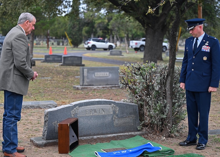 U.S. Air Force Col. Matthew Reilman, 17th Training Wing commander, and Tom Green County Judge, Steve Floyd, pay their respects to Seaman 1st Class Walton O. Irwin during his memorial during the Pearl Harbor Remembrance Day ceremony at Fairmount Cemetery, San Angelo, Texas, Dec. 7, 2022. Irwin’s memorial plaque was placed next to his parents’ graves in his hometown of San Angelo. (U.S. Air Force photo by Senior Airman Ethan Sherwood)