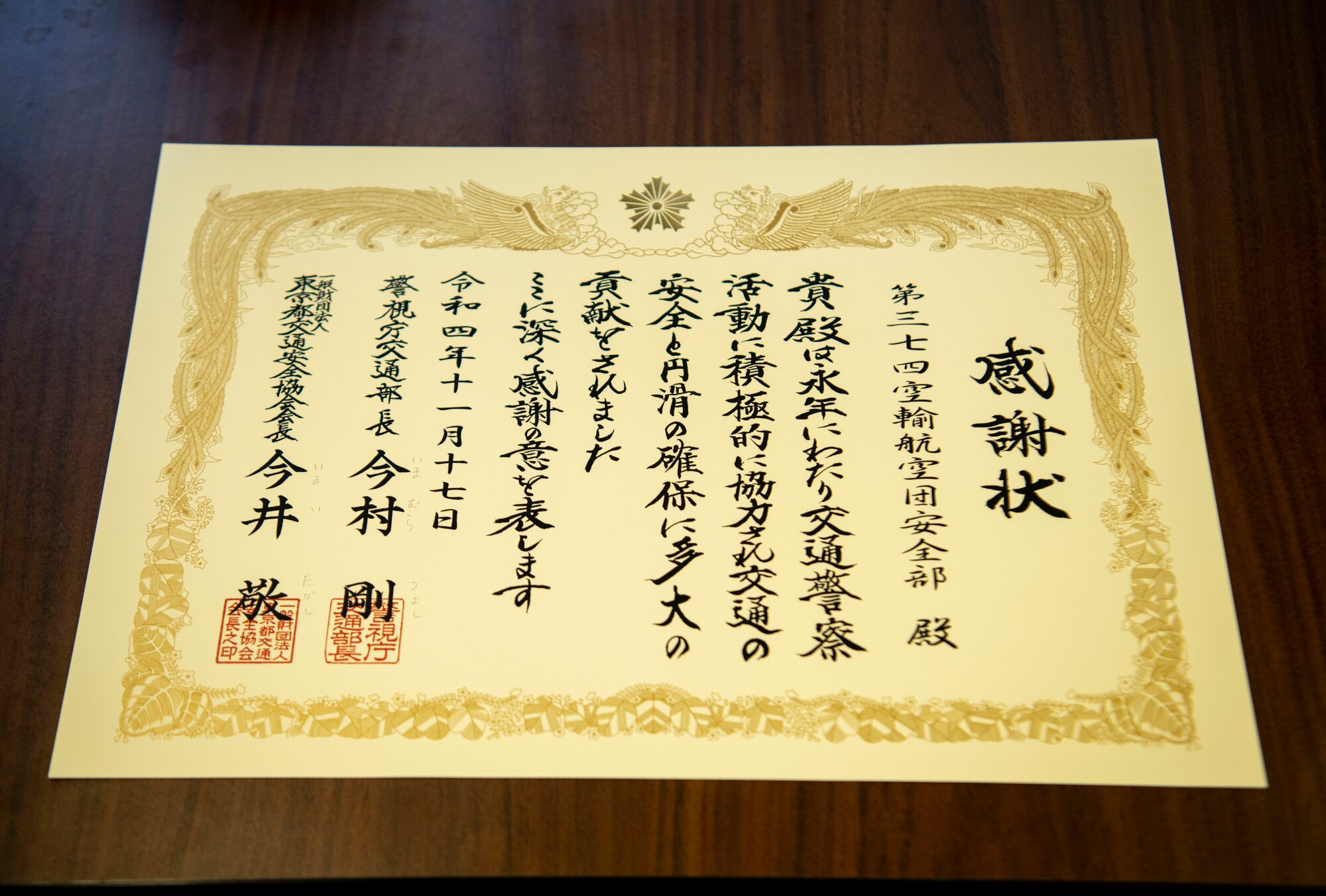 A certificate is displayed on a table with Japanese kanji describing the safety award