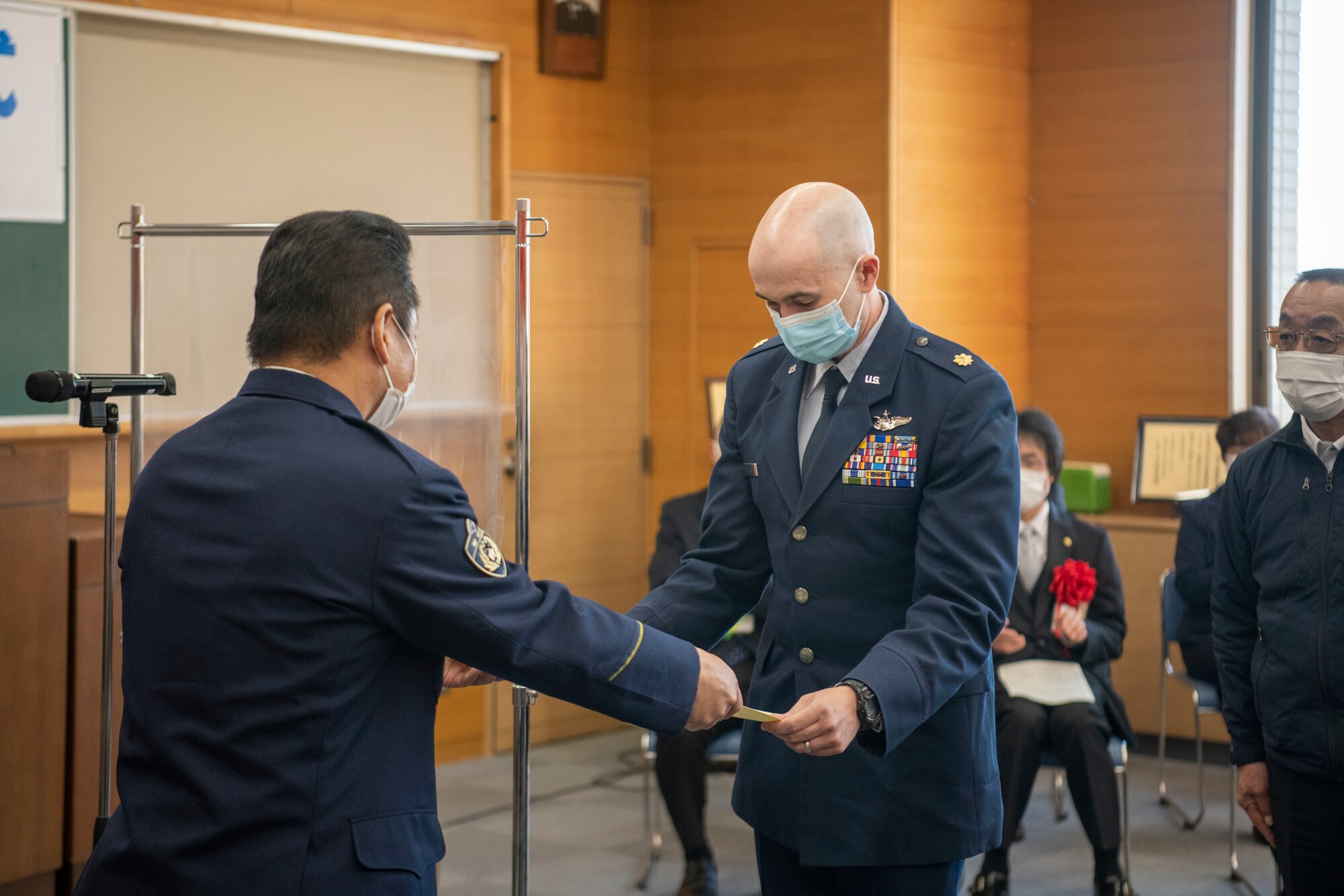 A man presents an award to another person.