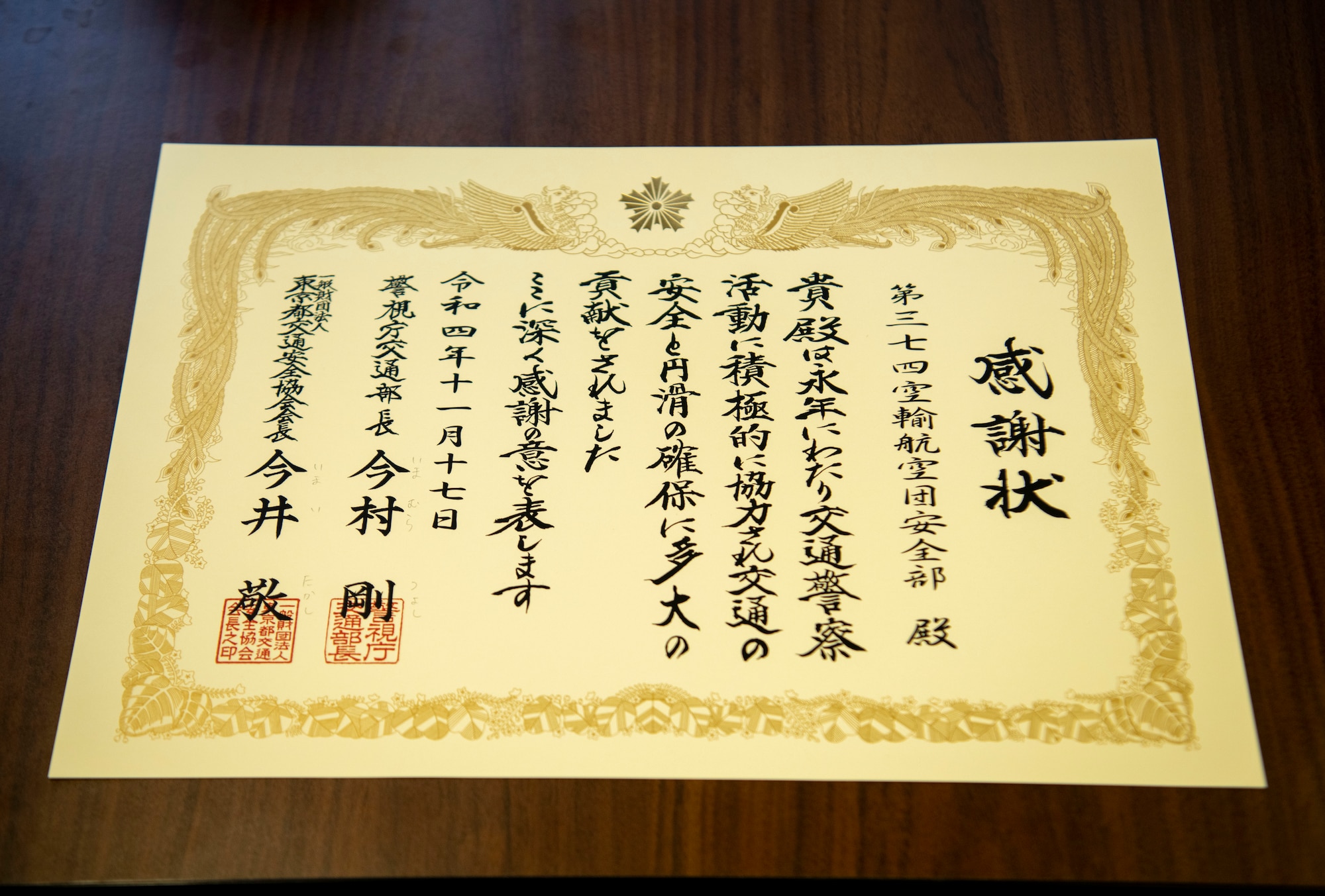A certificate is displayed on a table with Japanese kanji describing the safety award