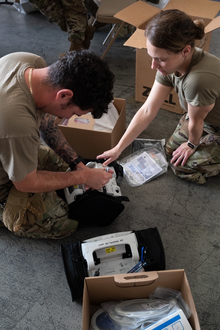 Photo of Airmen from the Alaska Air National Guard and contractors setting up a Tactical Shelter.