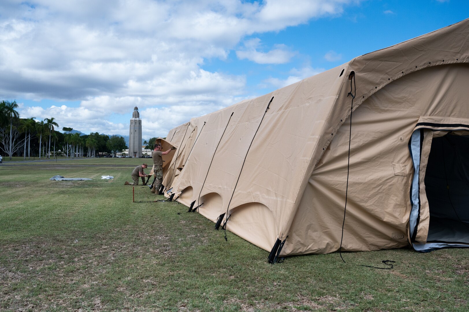 Photo of Airmen from the Alaska Air National Guard and contractors setting up a Tactical Shelter.