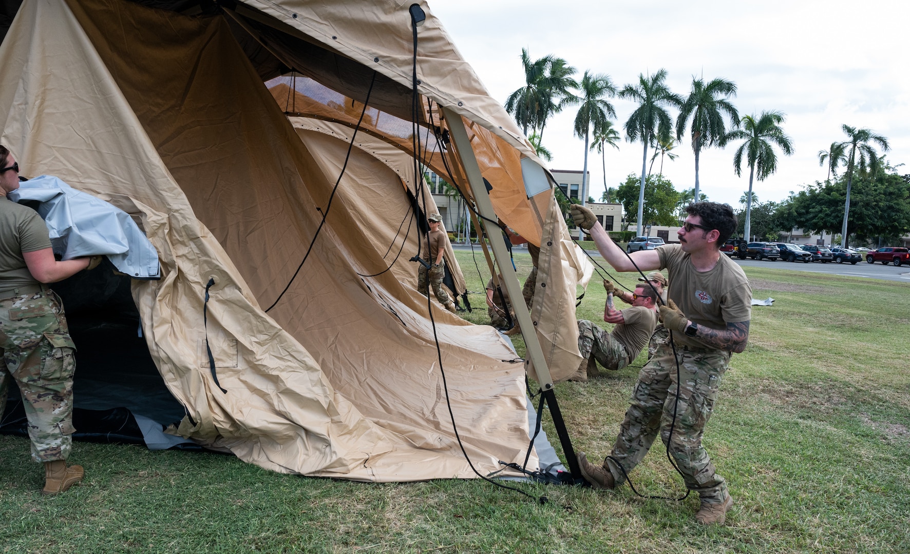 Photo of Airmen from the Alaska Air National Guard and contractors setting up a Tactical Shelter.