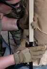 Photo of Airmen from the Alaska Air National Guard and contractors setting up a Tactical Shelter.