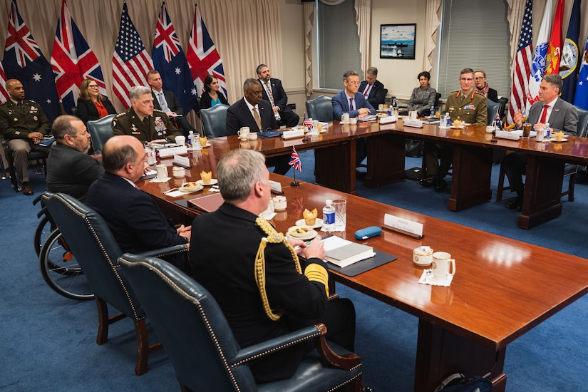 A group of people meet around a large table.