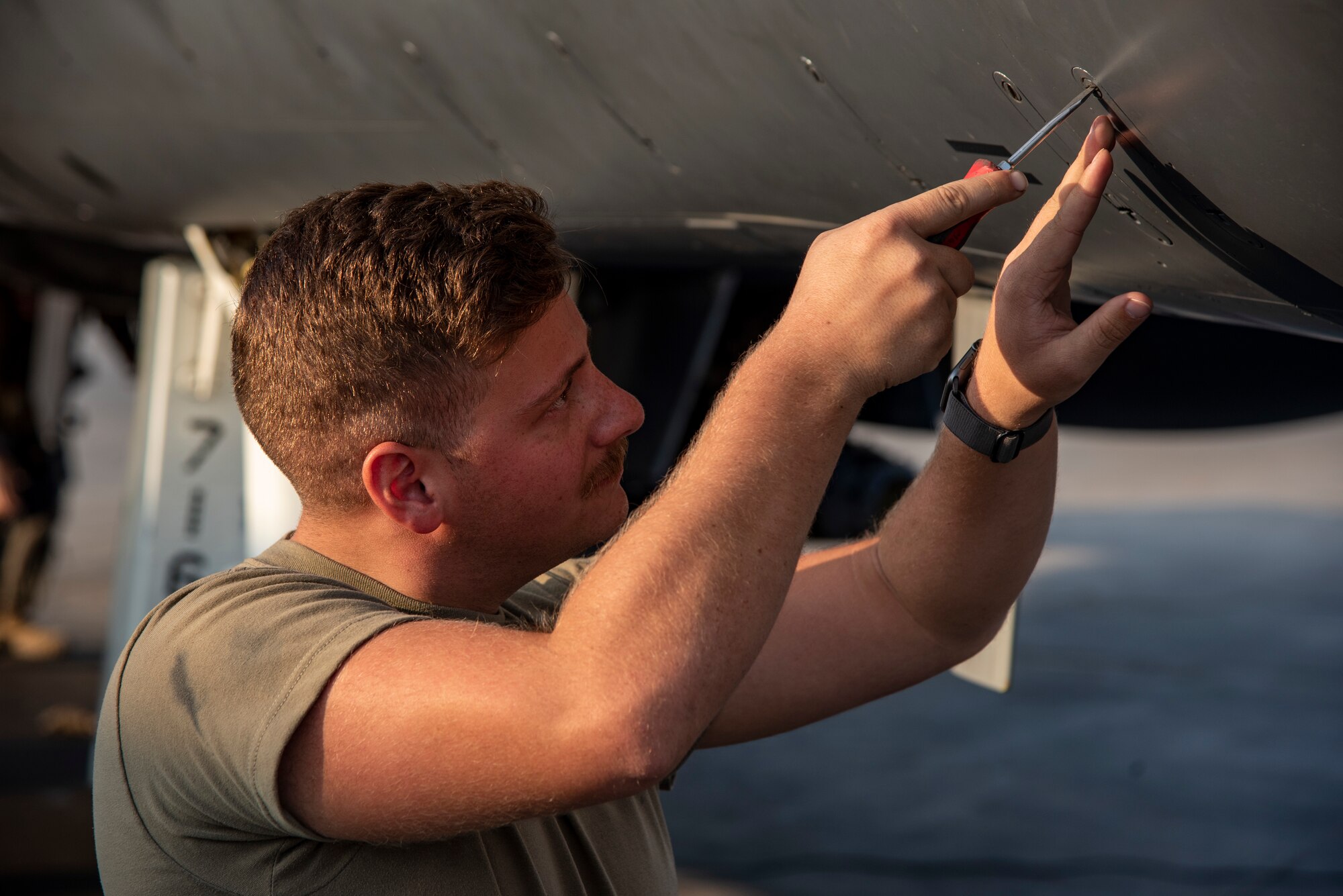 Airman 1st Class William Phillips, 389th Expeditionary Fighter Squadron crew chief, tightens a panel during a preflight inspection on an F-15E Strike Eagle at an undisclosed location, Southwest Asia, Nov. 15, 2022. Preflight checks allow aircrew to guarantee that all systems are working properly, reducing the risk of in-flight emergencies. (U.S. Air Force photo by: Tech. Sgt. Jim Bentley)