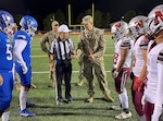 Image of Military officers on the football field with football players