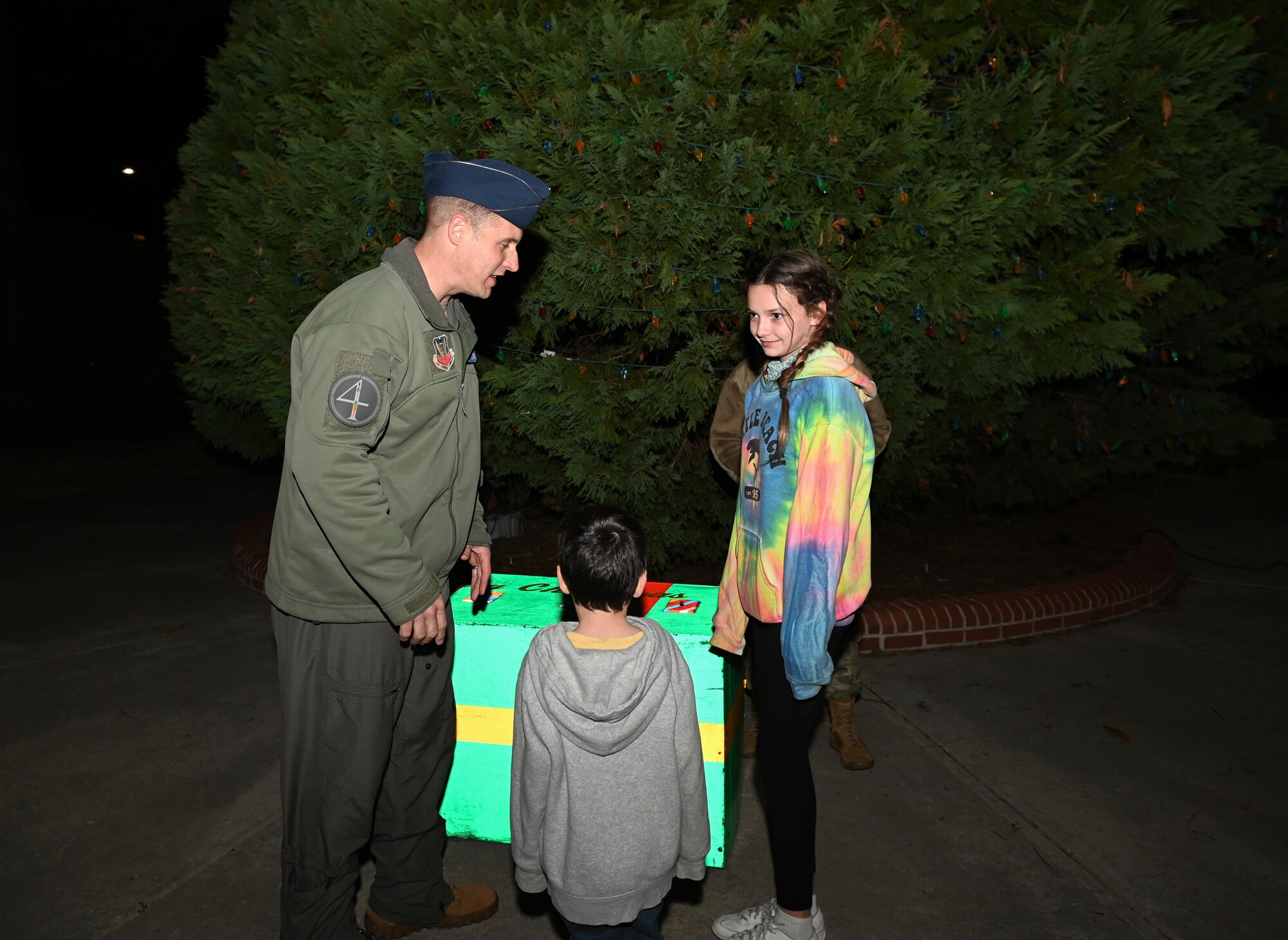 Col. Lucas Teel, 4th Fighter Wing commander, Maddison and Brantley Ellis dependents of Tech. Sgt. Shaun Ellis, 4th Equipment Maintenance Squadron aerospace ground equipment craftsman, count down before switching on the lights of a holiday tree during the Holiday Village and vendor fair at Seymour Johnson Air Force Base, North Carolina, Dec. 5, 2022. The honor of lighting the tree at Seymour Johnson was done by family members of a deployed service member. (U.S. Air Force photo by Airman 1st Class Rebecca Sirimarco-Lang)