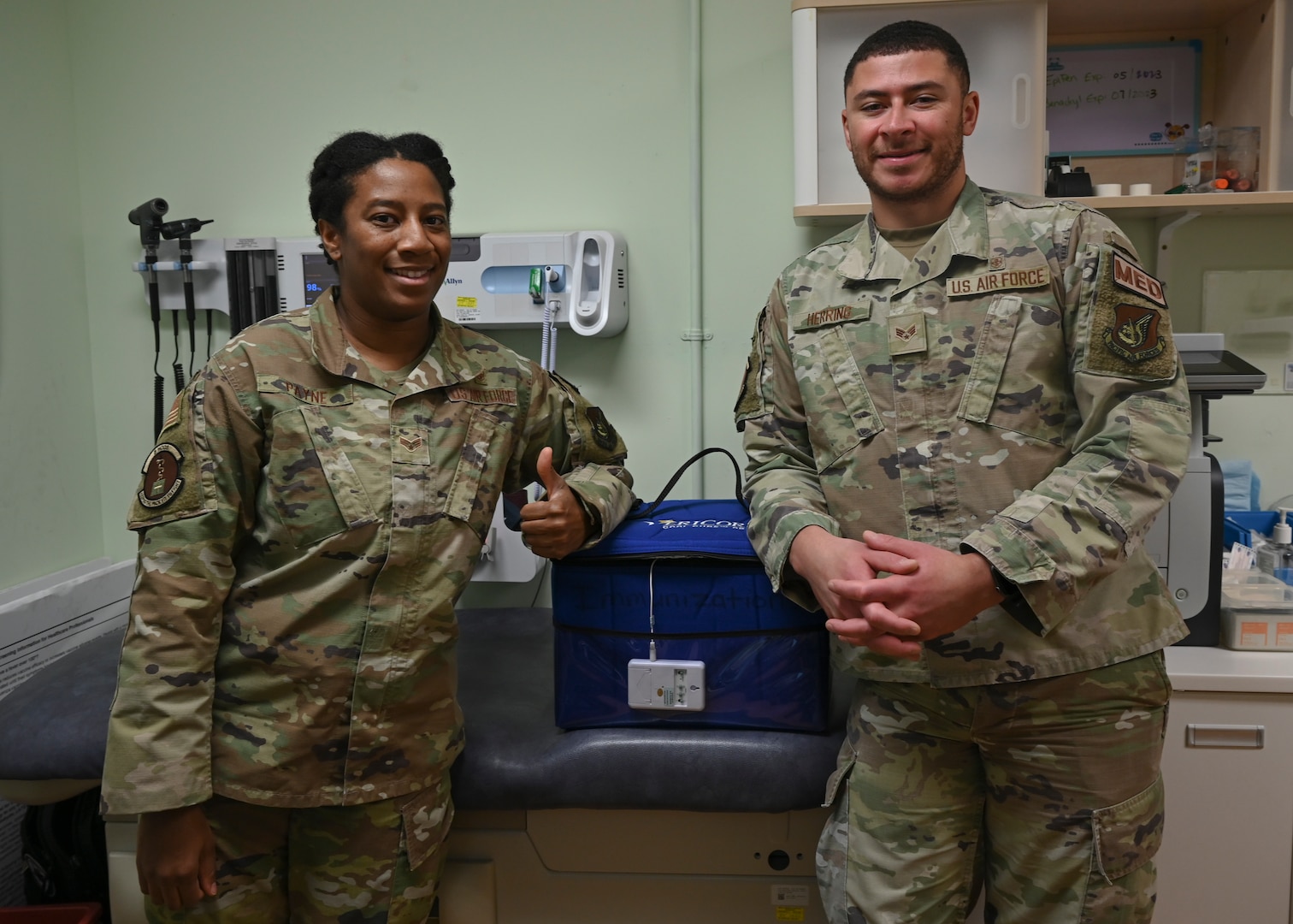 Senior Airman Lydia Payne (left) and Senior Airman Aidan Herring, 8th Healthcare Operations Squadron allergy and immunology technicians, pose for a photo at Kunsan Air Base, Republic of Korea, Nov. 21, 2022. To keep the injection shots in prime condition, doses are kept at freezing cold temperatures, as low as -20 degrees Celsius. (U.S. Air Force photo by Senior Airman Akeem K. Campbell)