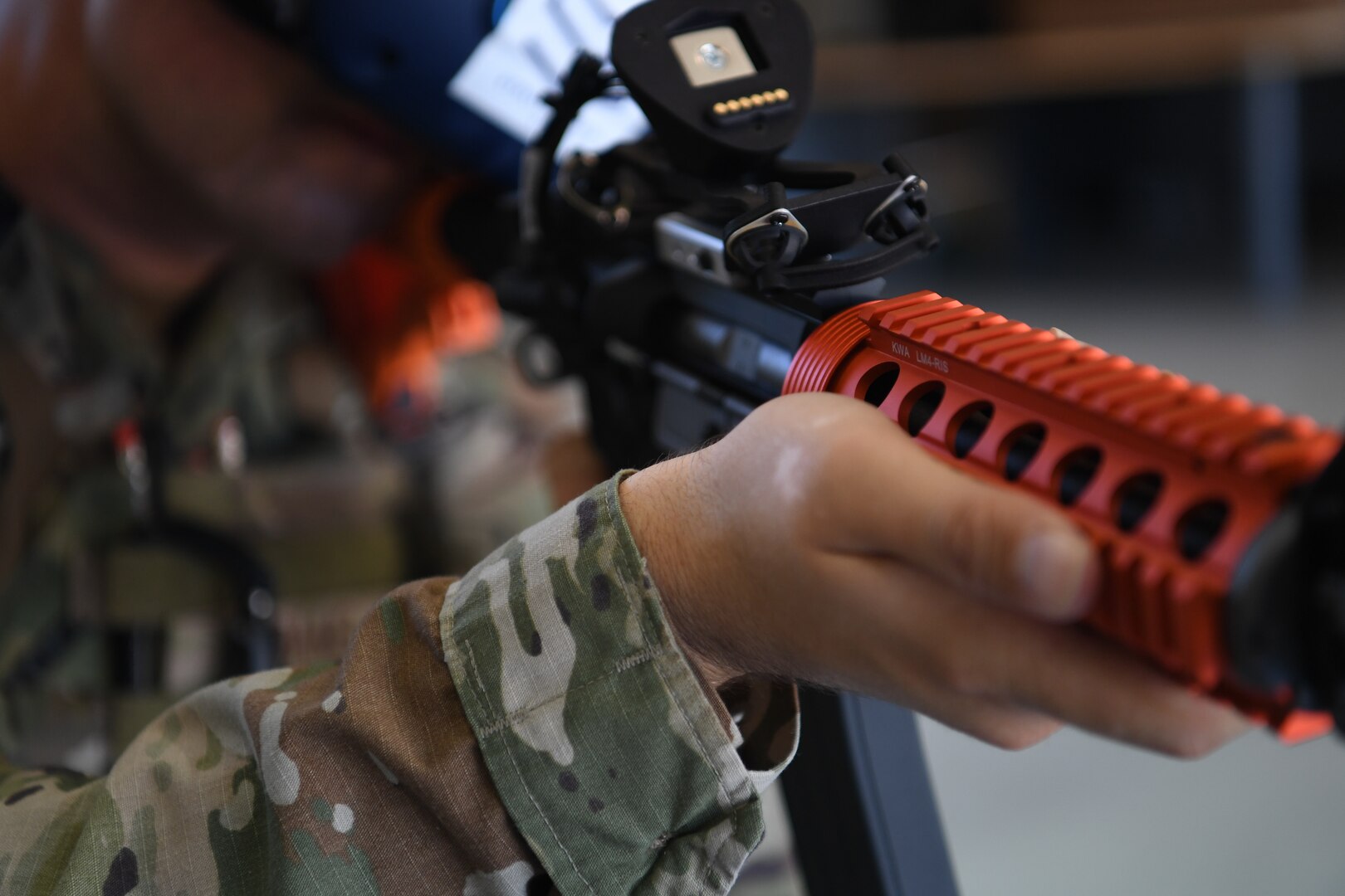 Senior Airman Jeremy Adams of the 195th Wing Security Forces Flight, California Air National Guard, demonstrates new upgrades to the Street Smarts VR System Aug. 6, 2022, at Sepulveda Air Guard Station, Van Nuys, California. The upgrades incorporate a gas-operated, orange practice rifle that mimics the weight and recoil of the standard-issue M18 arms into the SSVRS's realistic reaction training scenarios.