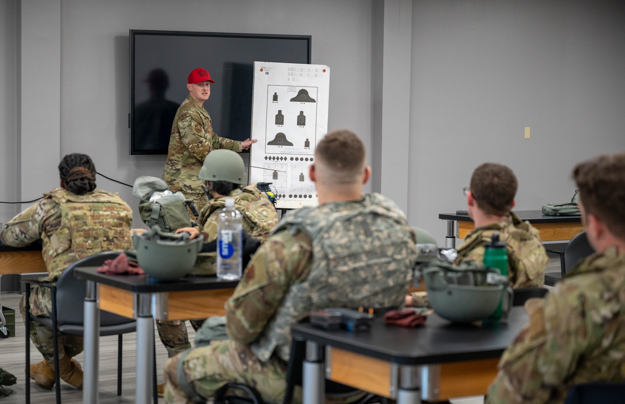 U.S. Air Force Staff Sgt. Cameron Saylor, 633d Security Forces Squadron combat arms instructor, highlights what targets the Airmen will shoot with the iron-sights and their M68 Close Combat Optic Reflex sights during a Combat Arms Training and Maintenance qualification course at Joint Base Langley-Eustis, Virginia, Nov. 30, 2022.